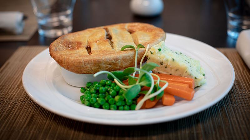 Delicious chicken pot pie served with steamed vegetables and mashed potato.